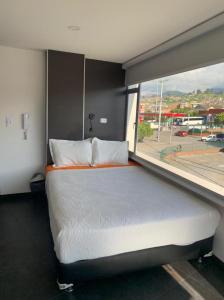 a bedroom with a large bed with a large window at HOTEL MC in Pasto