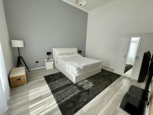 um quarto branco com uma cama e um tapete em Napoli Comfort Home em Nápoles