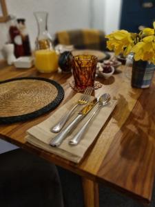 a wooden table with utensils on top of it at Abhaig Boutique B&B - Small & luxurious in a great location! in Uig