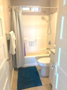 een badkamer met een toilet en een douche met een blauw tapijt bij Casita California - Private house with backyard in San Diego
