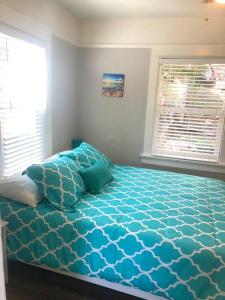 een slaapkamer met een bed met blauwe lakens en een raam bij Casita California - Private house with backyard in San Diego