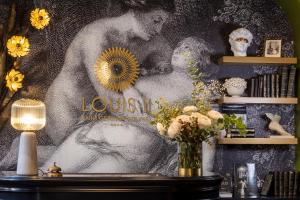 a wall with a painting of a man and a woman at Hotel Louis II in Paris