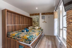 um quarto com uma cama e uma cabeceira em madeira em Chez Ingres - Le Nid - Joyau caché en centre ville em Montauban