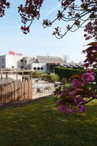 a yard with a fence and a table and chairs at ibis Saintes in Saintes