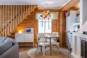 Pyhä Saukonpiilo في Pelkosenniemi: مطبخ وغرفة معيشة مع طاولة وكراسي