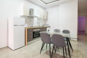 a kitchen with a table and chairs and a refrigerator at Luxury Suite Fuengirola 1 in Fuengirola