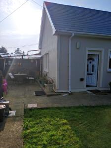 a small white house with a table and a patio at Miriam's Cottage West Cork in Drom dhá Liag