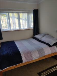 1 cama en un dormitorio con ventana en Miriam's Cottage West Cork, en Drom dhá Liag