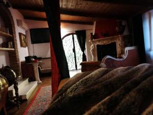 um quarto com uma cama, uma lareira e uma janela em La stanza nel parco em Anguillara Sabazia