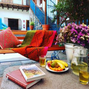 une table avec un livre et une assiette de fruits dans l'établissement Terra Sagrada Cusco, à Cusco