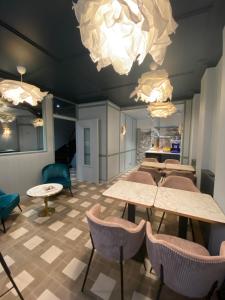 a waiting room with tables and chairs and lights at Amadeus Hotel in Paris