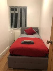 - un lit avec une couverture rouge et un oreiller rouge dans l'établissement Modern Newgate Apartments - Kingsbury Underground, All Local Amenities on Your Doorstep, à Wealdstone