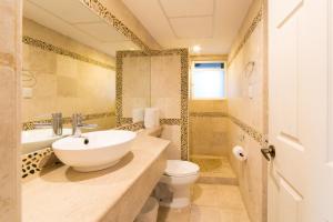 a bathroom with a sink and a toilet at Hotel Villamar Princesa Suites in Acapulco