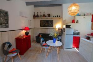eine Küche und ein Wohnzimmer mit einem Tisch und Stühlen in der Unterkunft LUBERON DES ARTISTES 2 in Apt