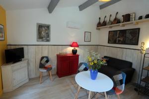 ein Wohnzimmer mit einem Sofa und einem Tisch mit Blumen in der Unterkunft LUBERON DES ARTISTES 2 in Apt