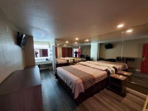a hotel room with a large bed and a mirror at River Inn Motel in San Antonio