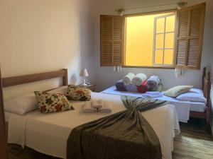 1 Schlafzimmer mit 2 Betten und einem Fenster in der Unterkunft Pouso da Ju in Tiradentes