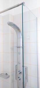une douche avec une porte en verre dans une salle de bain dans l'établissement George's Place Sifnos - apartments, à Apollonia