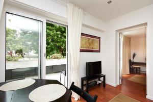 a living room with a table and a large window at Villa Lunae - Sintra Flats in Sintra
