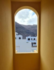 a window in a room with a view of buildings at Cliff View Orzola in Orzola