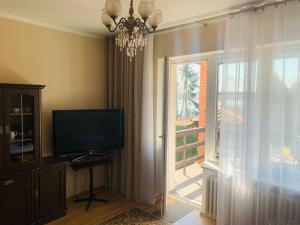 a living room with a television and a window at Apartament z widokiem na jezioro Ukiel in Olsztyn