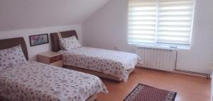 1 dormitorio con 2 camas y ventana en VISOKO Room en Visoko