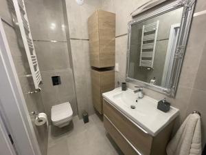 biała łazienka z umywalką i toaletą w obiekcie Apartament Luna Baltic Marina Residence w Kołobrzegu