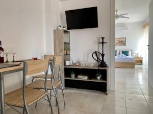 a living room with a table and chairs and a tv on the wall at Peaceful Apartment, in the nature, with yard "3" in Zipárion