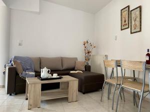 Peaceful Apartment, in the nature, with yard "3" في Zipárion: غرفة معيشة مع أريكة وطاولة وكراسي