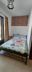 a bed sitting in a room with a brick wall at Star Sianna Village Rooms to let in Siána