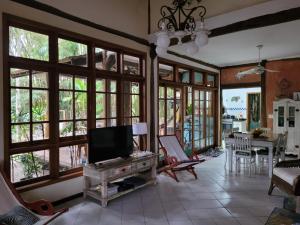 a living room with large windows and a flat screen tv at Casa da árvore em Paúba . in São Sebastião