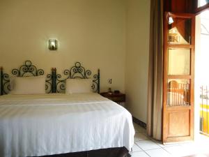 a bedroom with a large bed with white sheets at Hotel Concierge Plaza Colima in Colima