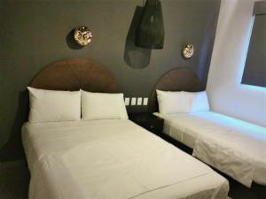 duas camas sentadas uma ao lado da outra num quarto em HM HOTEL EXPRESS em Colima