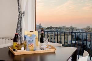 un vassoio con bottiglie di vino su un tavolo sul balcone di Relais Mirage Sorrento a Sorrento