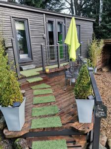 een achtertuin met een tiny house met een terras bij The Wee Den in Balfron