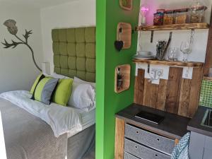 a bedroom with a bed and a green wall at The Wee Den in Balfron