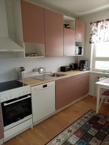 a kitchen with white appliances and a sink at Citykoti in Varkaus