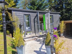 una casa pequeña en un jardín con patio en The Wee Den, en Balfron