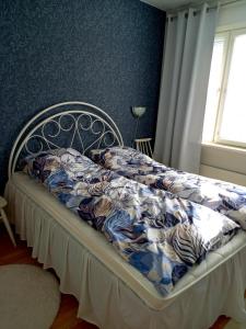 ein Bett mit einer blauen und weißen Bettdecke in einem Schlafzimmer in der Unterkunft Citykoti in Varkaus