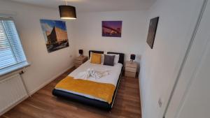 a bedroom with a bed in the corner of a room at Silverburn new house with free parking and nice garden in Glasgow