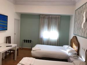 a bedroom with a bed and a desk at Hostal La Mexicana in Santander