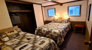 um quarto com duas camas e duas janelas em The Aspen Cabin em Wilmington