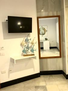 a wall with a mirror and a tv on a wall at Hotel Océano Centro in Santa Cruz de Tenerife