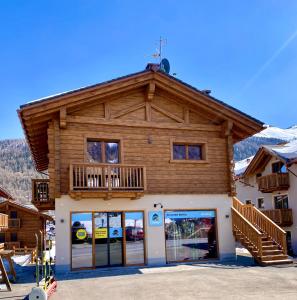 a log building with a balcony on top of it at Carosello Lodge Livigno in Livigno