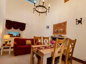 ein Wohnzimmer mit einem Tisch und einem roten Sofa in der Unterkunft The Bothy of Ballachulish House in Ballachulish