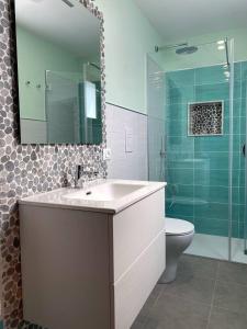 bagno con lavandino, servizi igienici e specchio di Attico a San Vito Lo Capo a San Vito lo Capo