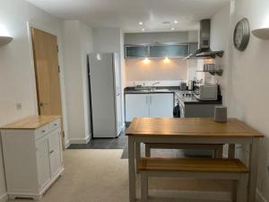 a kitchen with a refrigerator and a table in it at Apartment D102 in Kingsthorpe