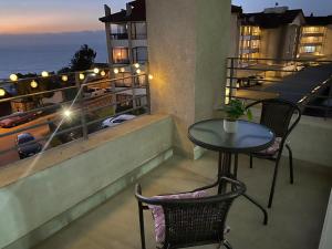 a table and chairs on a balcony with a view of the ocean at Depto. estudio con vista al mar in Viña del Mar