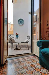 ein Wohnzimmer mit einem Tisch und Stühlen auf einer Terrasse in der Unterkunft Le terrazze segrete in Palermo
