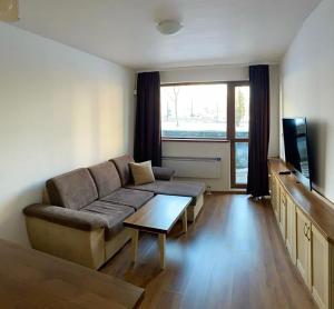 a living room with a couch and a tv at Belvedere luxury apartment in Bansko